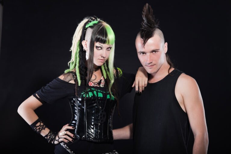 Couple of cyber punk girl with green blond hair and punk man with mohawk haircut. Expressive faces. Isolated on black background. Studio shot.